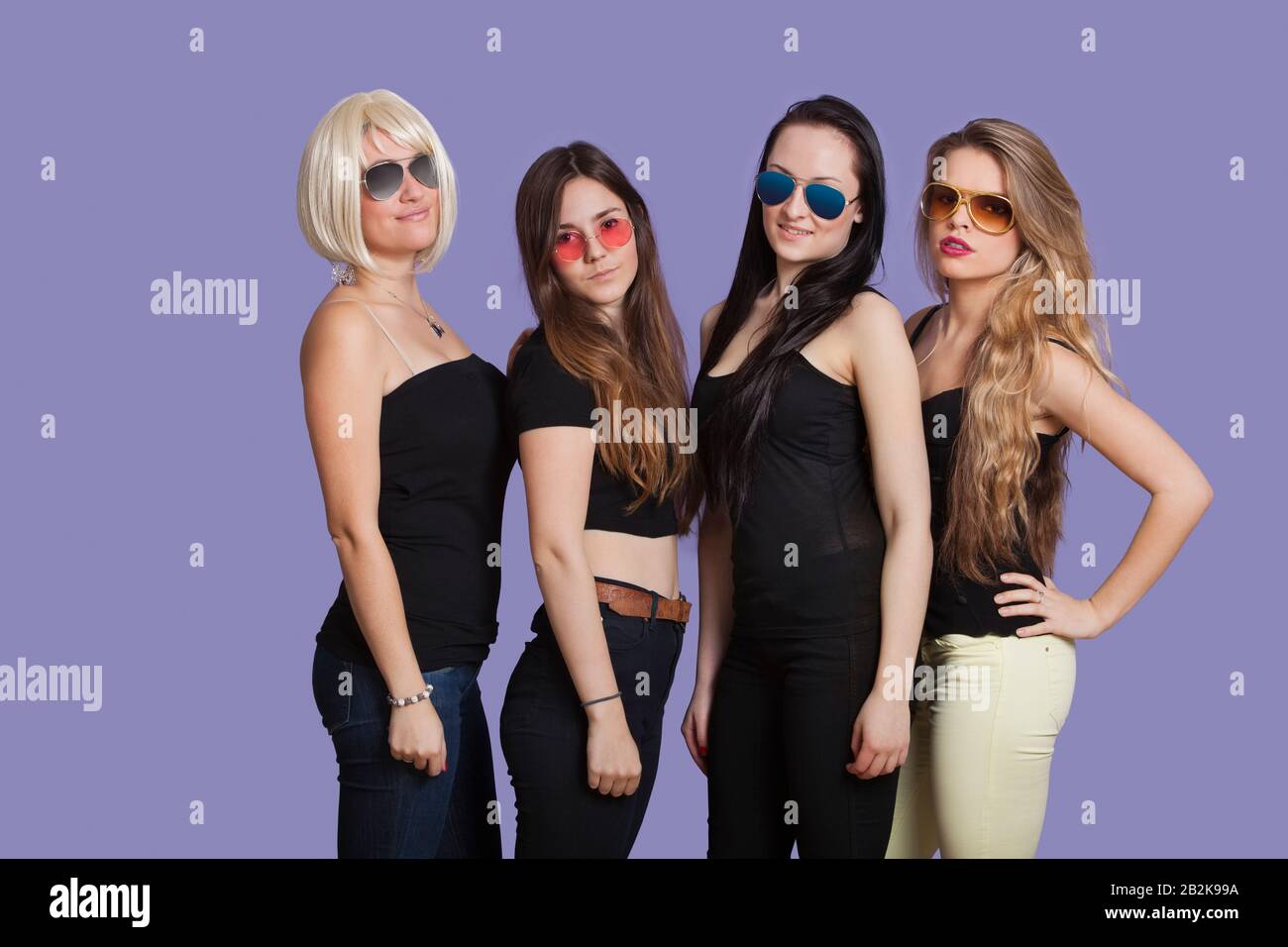Portrait of two beautiful multi ethnic women smiling over purple ...