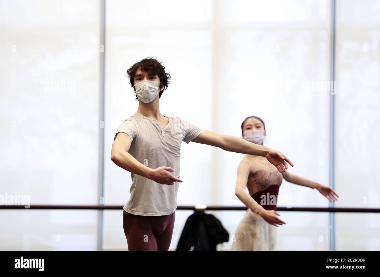 The ballet dancers are practicing in the rehearsal room by wearing ...