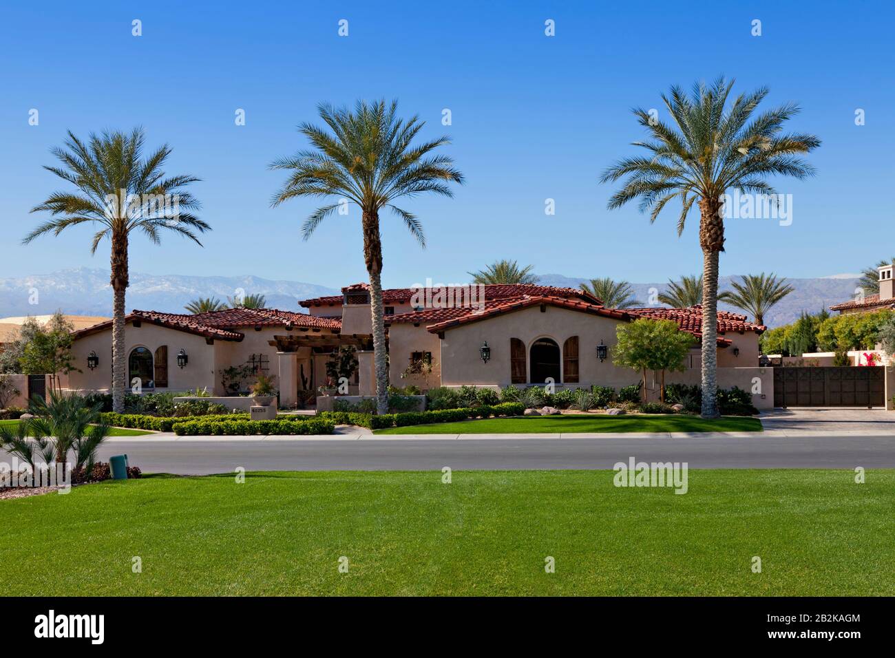 View across grass to façade of luxury suburban villa Stock Photo