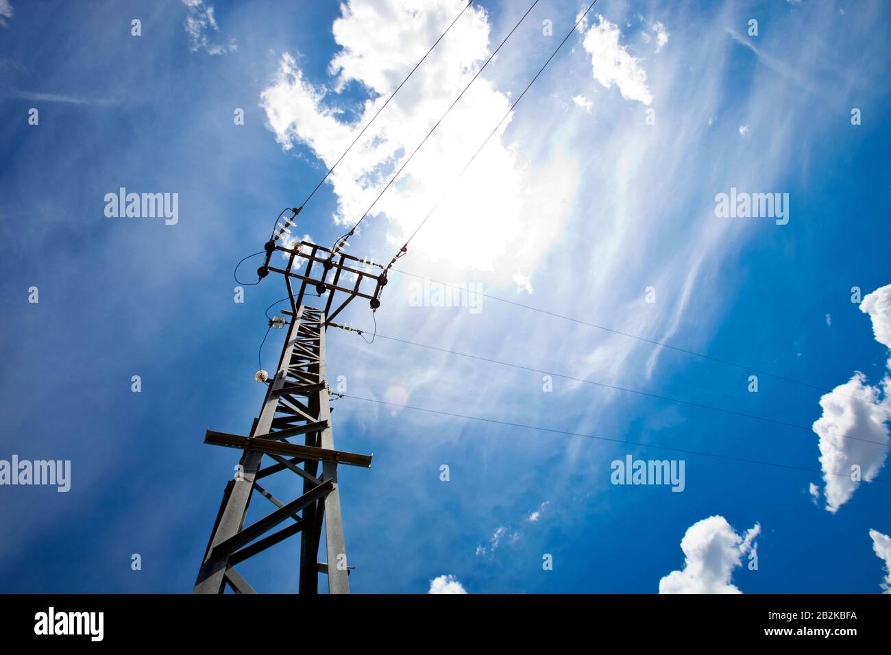Power lines against blue sky and sun Stock Photo - Alamy