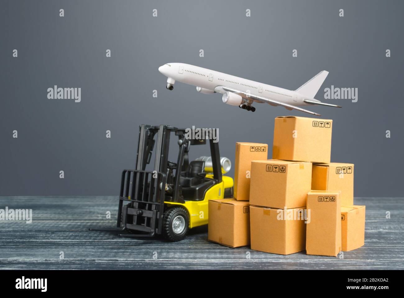Yellow Forklift truck and cardboard boxes and freight plane. Production, transport, cargo storage. Freight shipping. retail. Transportation logistics Stock Photo