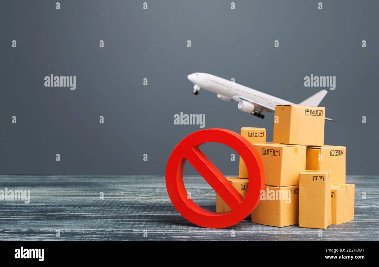 Cardboard boxes near a prohibition symbol NO and freight plane. Restrictions ban on import goods. Sanctions, trade embargo. Isolation quarantine. Manu Stock Photo