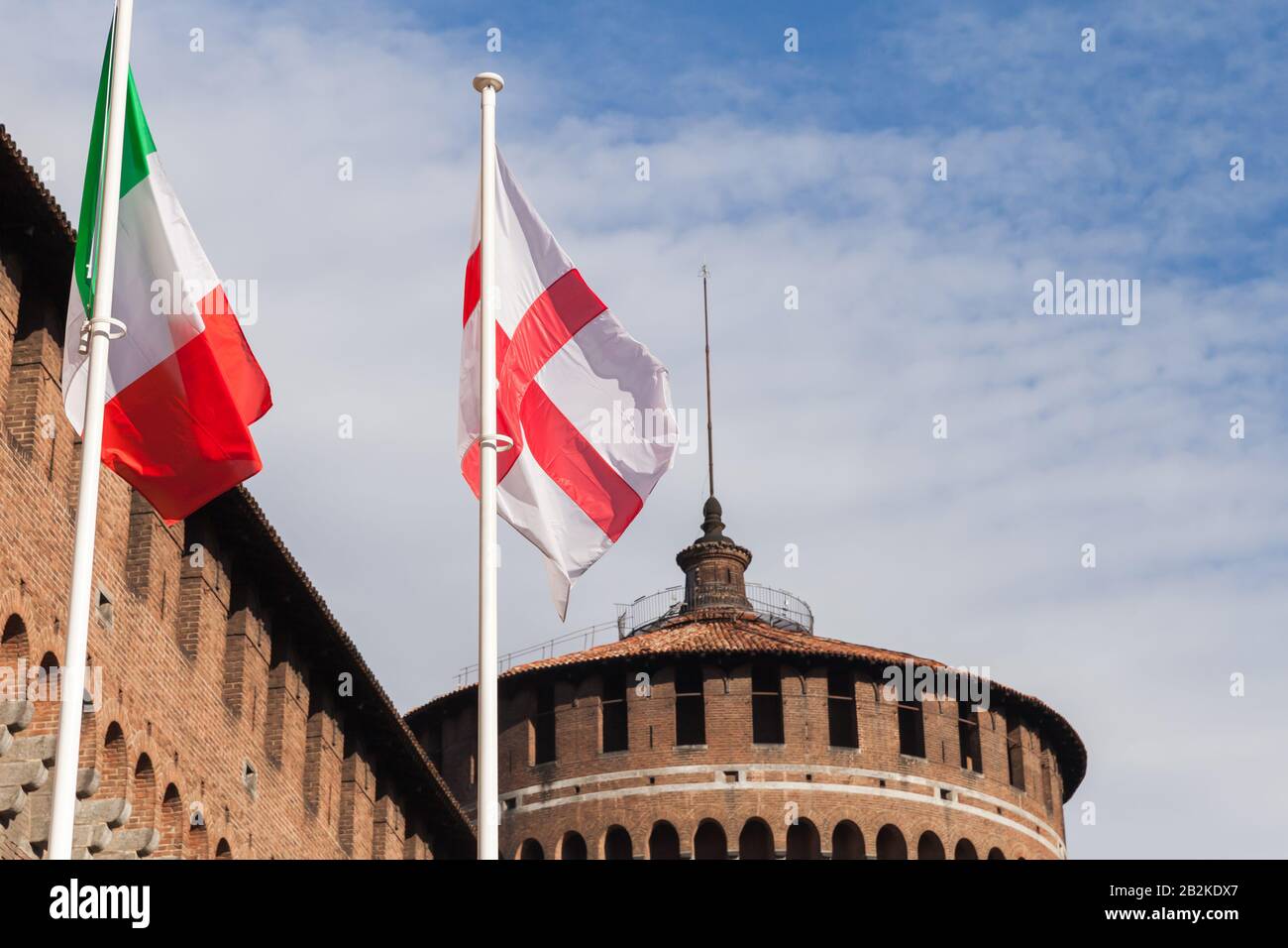 Flags of Milan and Italy with the Sforza Castle on a background at sunny day. It was built in the 15th century. Later renovated and enlarged, in the 1 Stock Photo