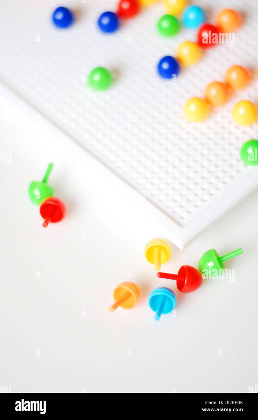 https://c8.alamy.com/comp/2B2KH4K/fun-with-a-pin-button-game-for-kids-white-plate-with-colorful-pins-2B2KH4K.jpg