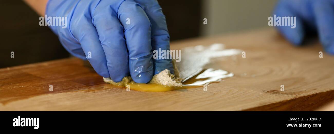 Gloved carpenter does hydrothermal treatment wood Stock Photo