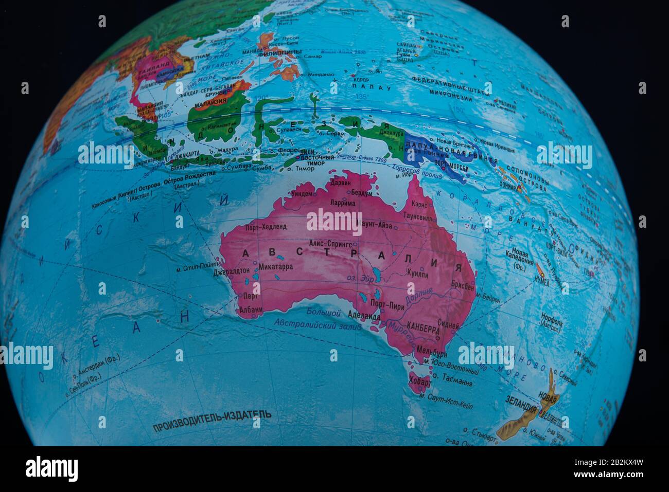 Australia - March 2020. Globe with Russian geographical names isolated on black bacground Stock Photo