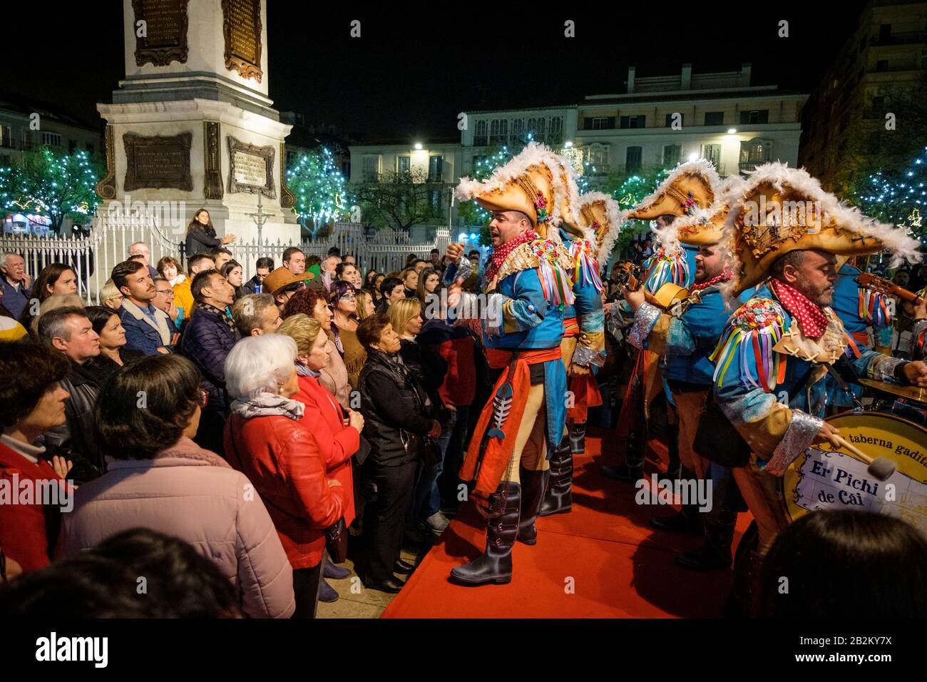 Satirical singers in fancy dress - comparsas and chirigotas - performing in Plaza de la Merced during the Málaga Carnival. Stock Photo