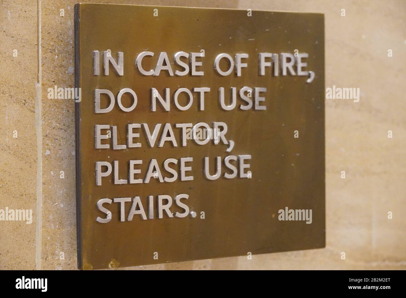 A sign that says, In Case Of Fire, Do Not Use Elevator, Please Use Stairs, which direct people of what to do in case of an fire emergency. Stock Photo