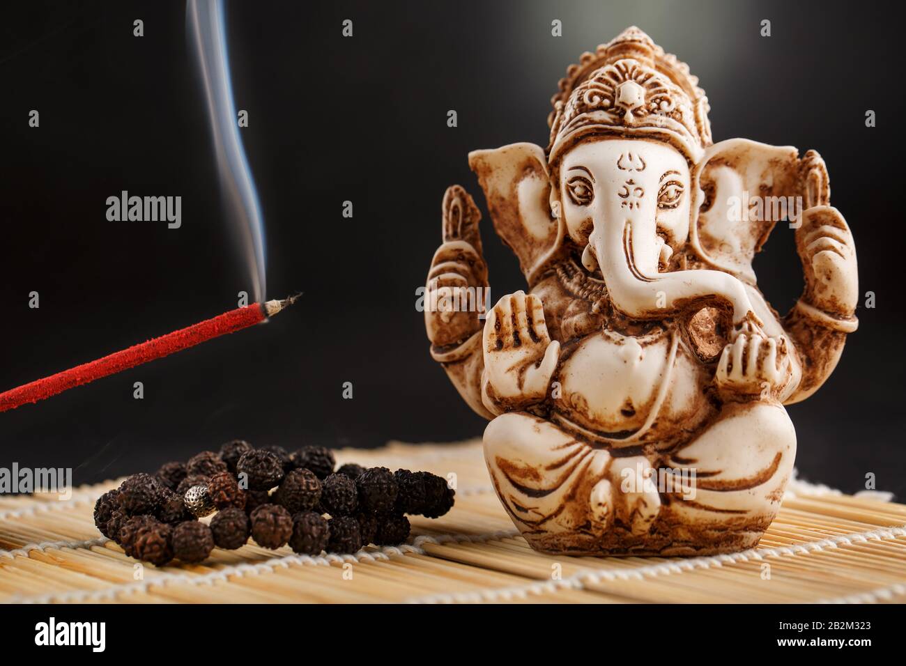 Ganesha on a black background. Statue and rosary with red smoldering  incense stick Ganesha sahasranama Stock Photo - Alamy