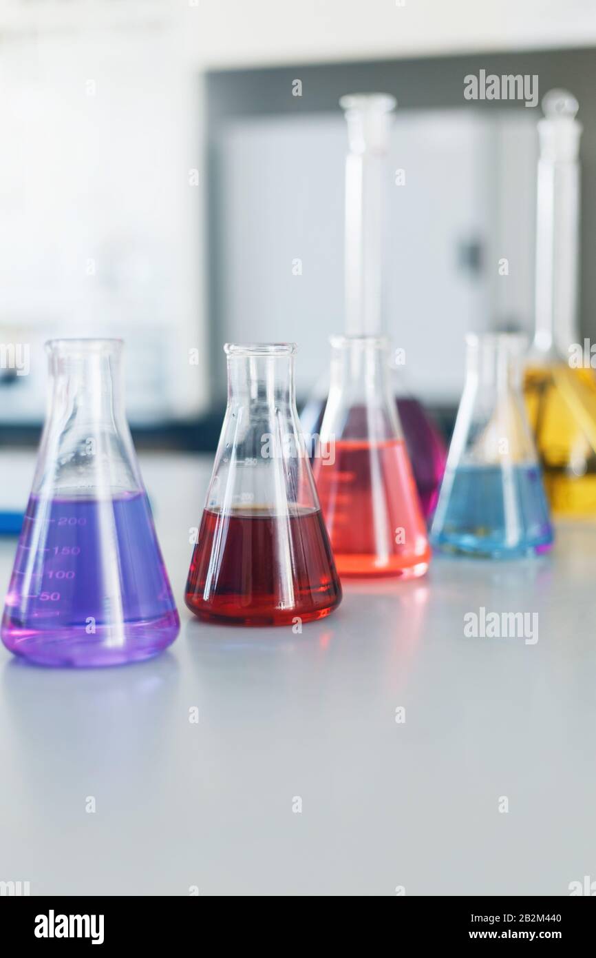 Chemical laboratory flask with blue purple-pink liquid stand on the table. Chemicals of liquid tests of test development, substances, poisons, additiv Stock Photo