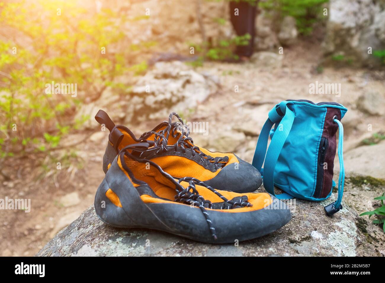 Orange climbing shoes and magnesium in a blue bag stand on a stone. Rock  Climbing Clothing Stock Photo - Alamy