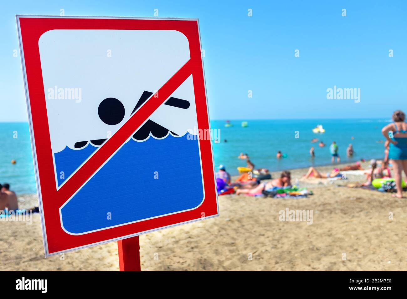 A sign on the beach is not allowed to swim People bathe and rest on the sea in spite of the sign