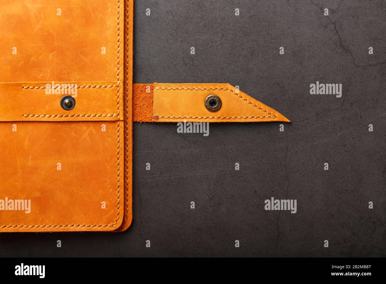 Wallet made of genuine brown nubuck leather on a dark background. Handmade leather items