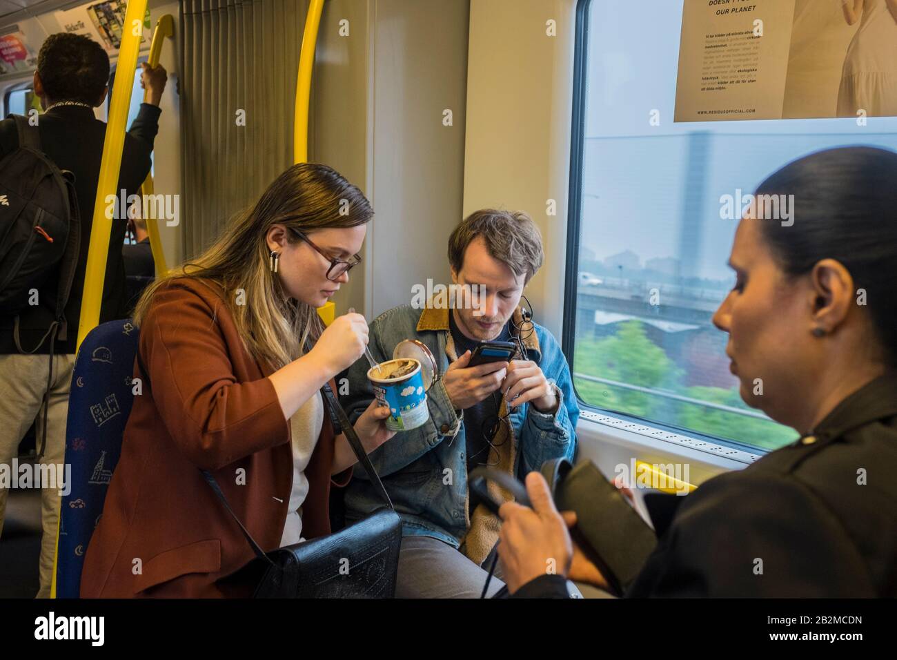 2 persons snacking on a Stockholm tube train Stock Photo