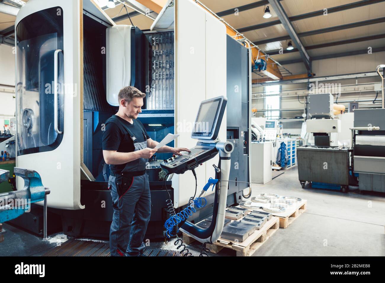 Worker in metal industry operating a modern cnc lathe Stock Photo