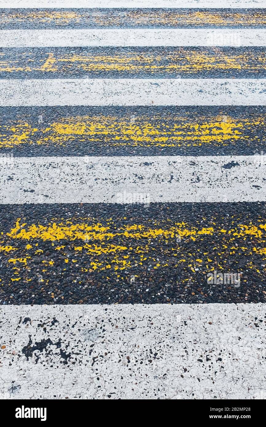 Pedestrian crossing, yellow and white stripes on wet asphalt in the ...