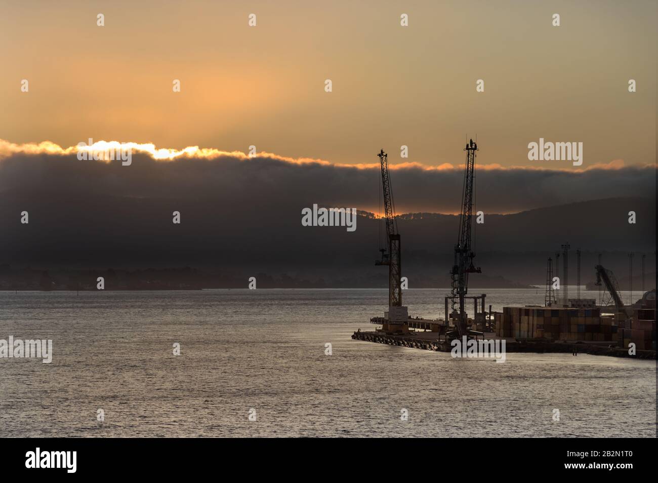 Two shipping cranes at the Bell Bay port in Tasmania at sunset