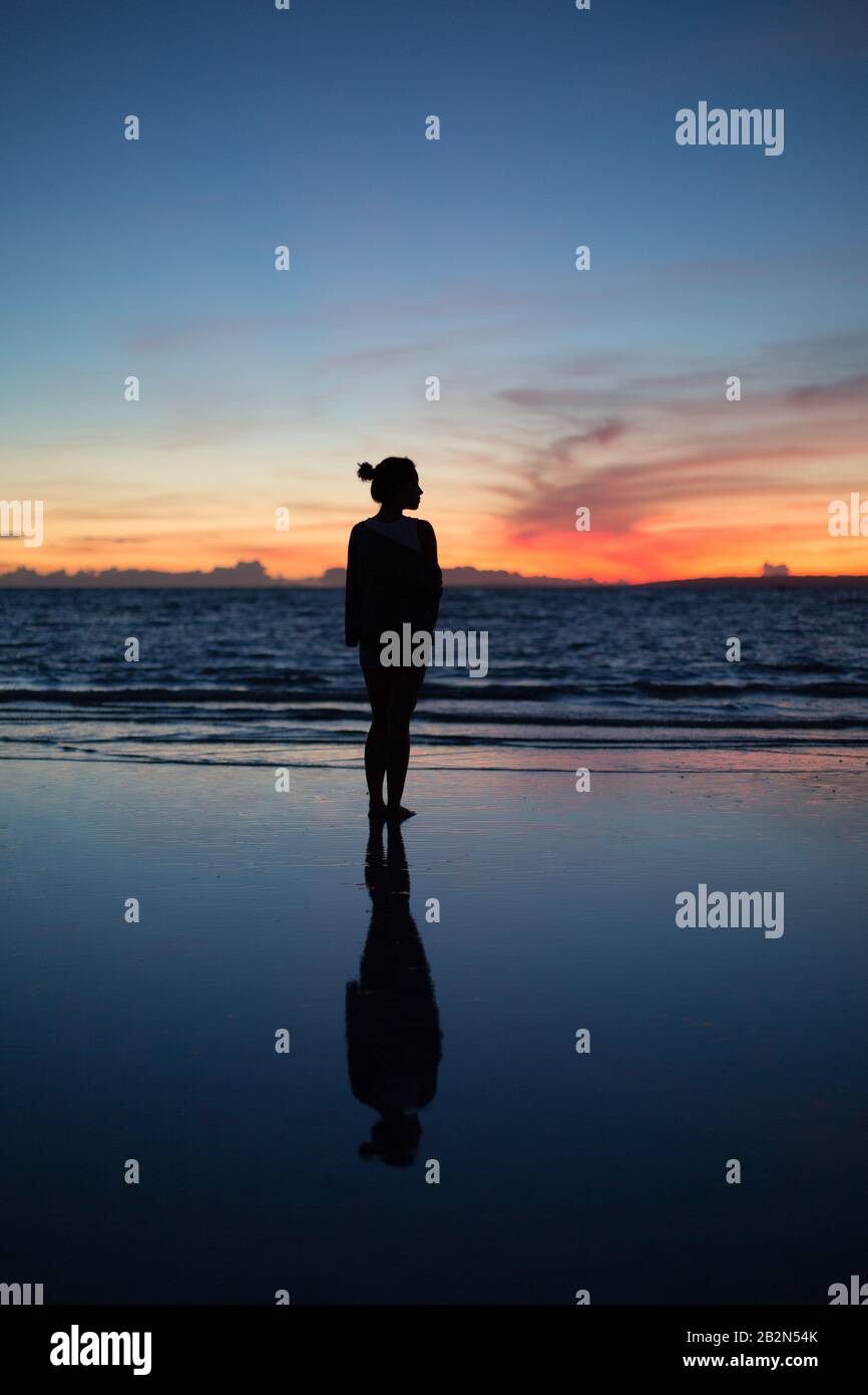 A woman stands alone at sunrise at Bantayan Island, Philippines Stock Photo