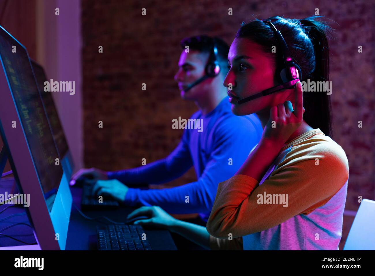 Caucasian man and a mixed race woman working late in a customer support office Stock Photo
