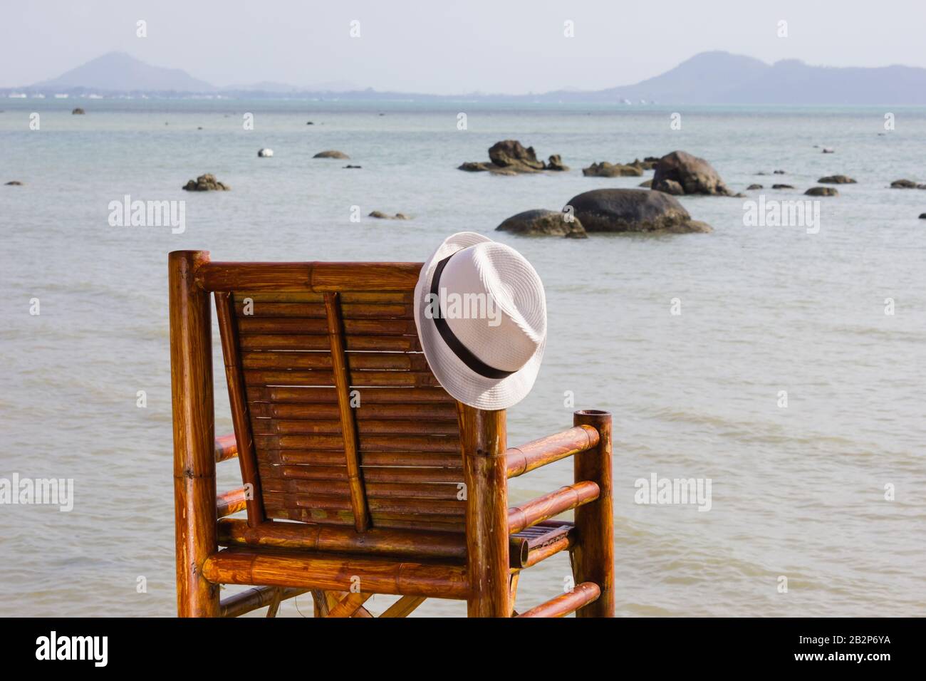 hat on a bamboo chair on the beach Stock Photo - Alamy