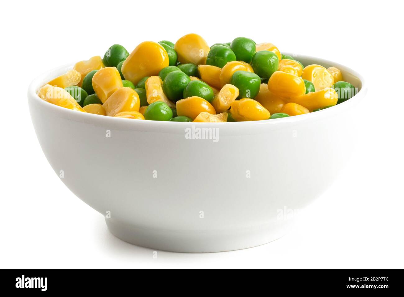 Fresh green garden peas and sweetcorn mix in a white ceramic bowl isolated on white. Low angle. Stock Photo