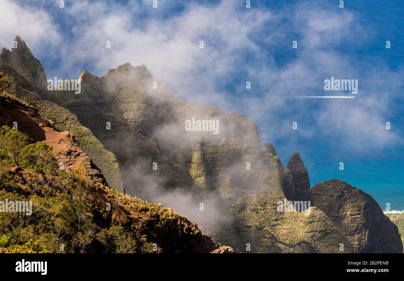 Fluted rocks of the Na Pali mountains through the clouds from Kalalau lookout on Kauai Stock Photo