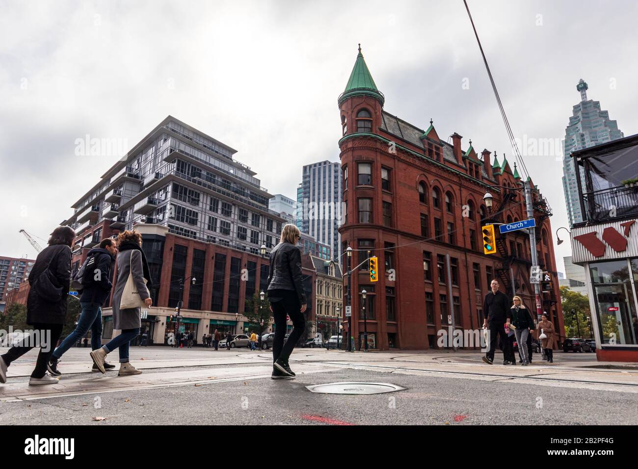 People walking across the street in-front of the famous Gooderham Building / Flatiron Building in Toronto. Stock Photo