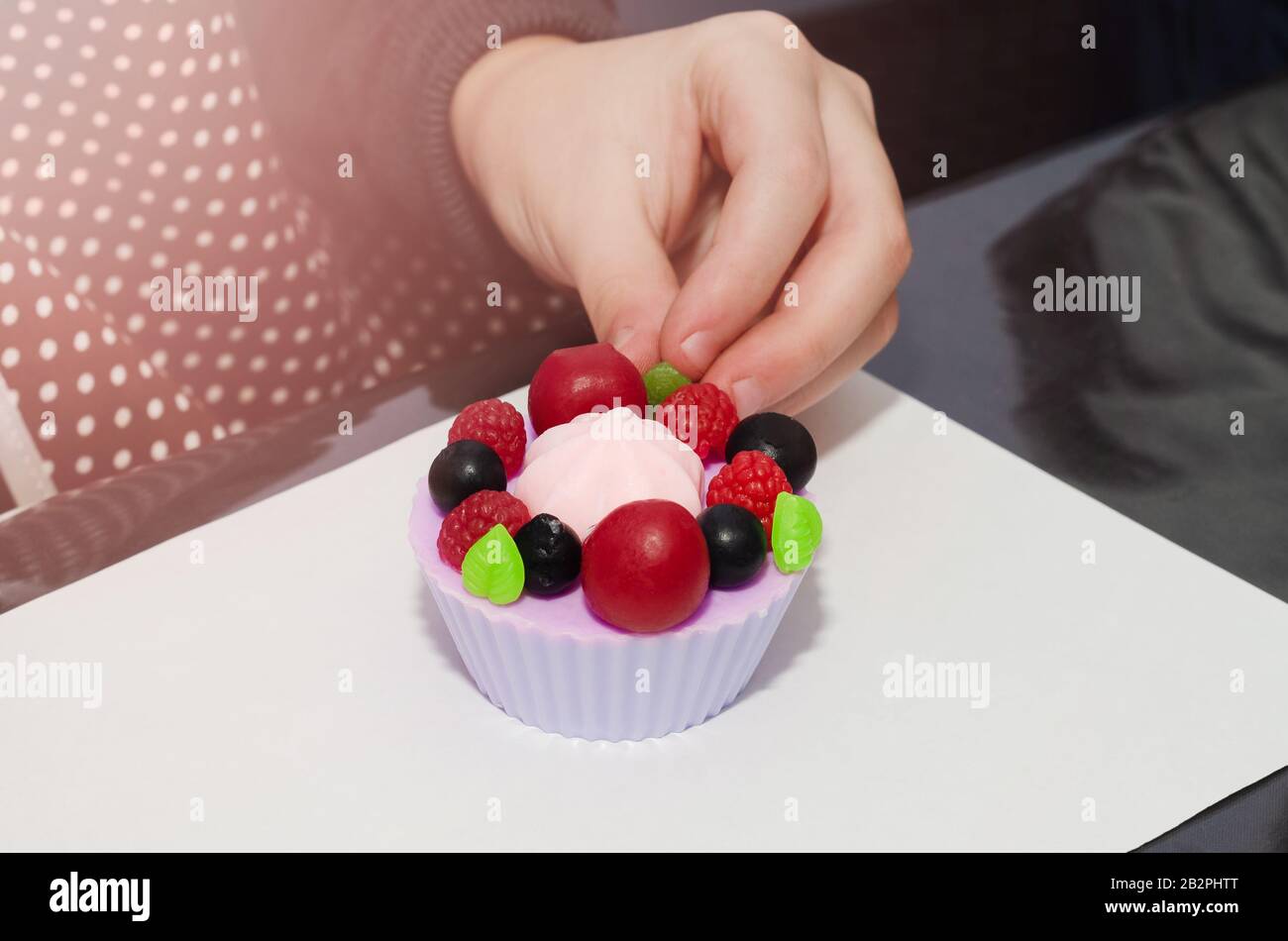 Fragrant berry bath soap is decorated with a child's hand. Stock Photo