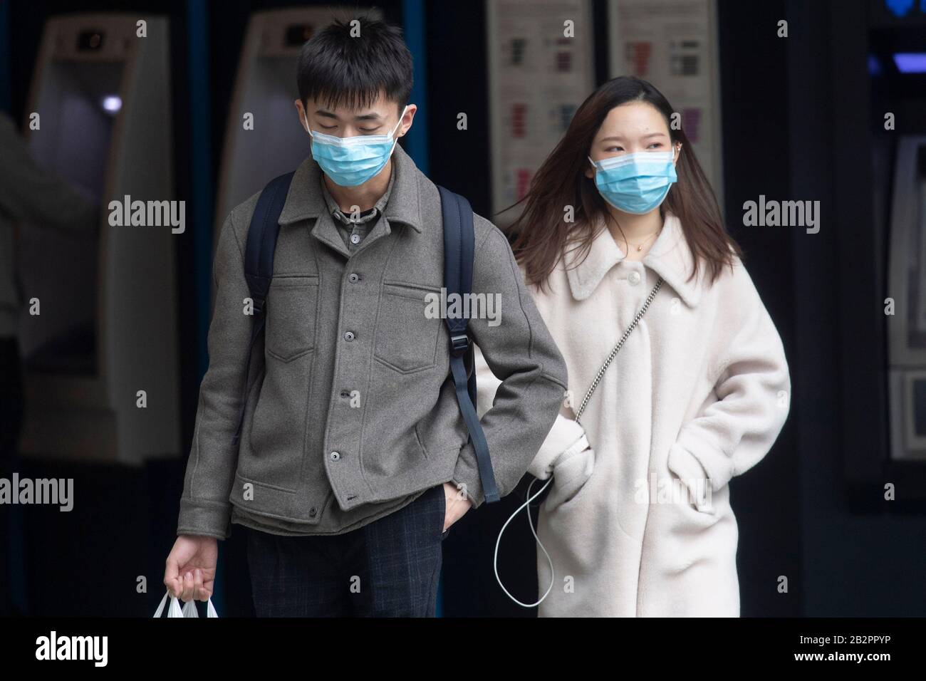 London, Britain. 3rd Mar, 2020. A man and a woman wearing face masks walk past a store in central London, Britain, on March 3, 2020. British Prime Minister Boris Johnson on Tuesday set out the government's action plan to tackle the spread of the novel coronavirus, as the number of infections reached 51 across the country. Credit: Ray Tang/Xinhua/Alamy Live News Stock Photo