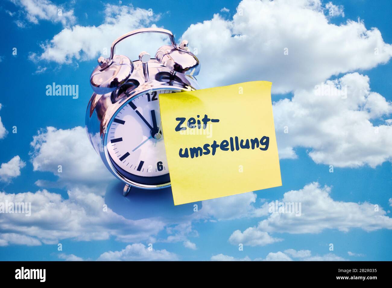 alarm clock with sticky note with german word Zeitumstellung (time