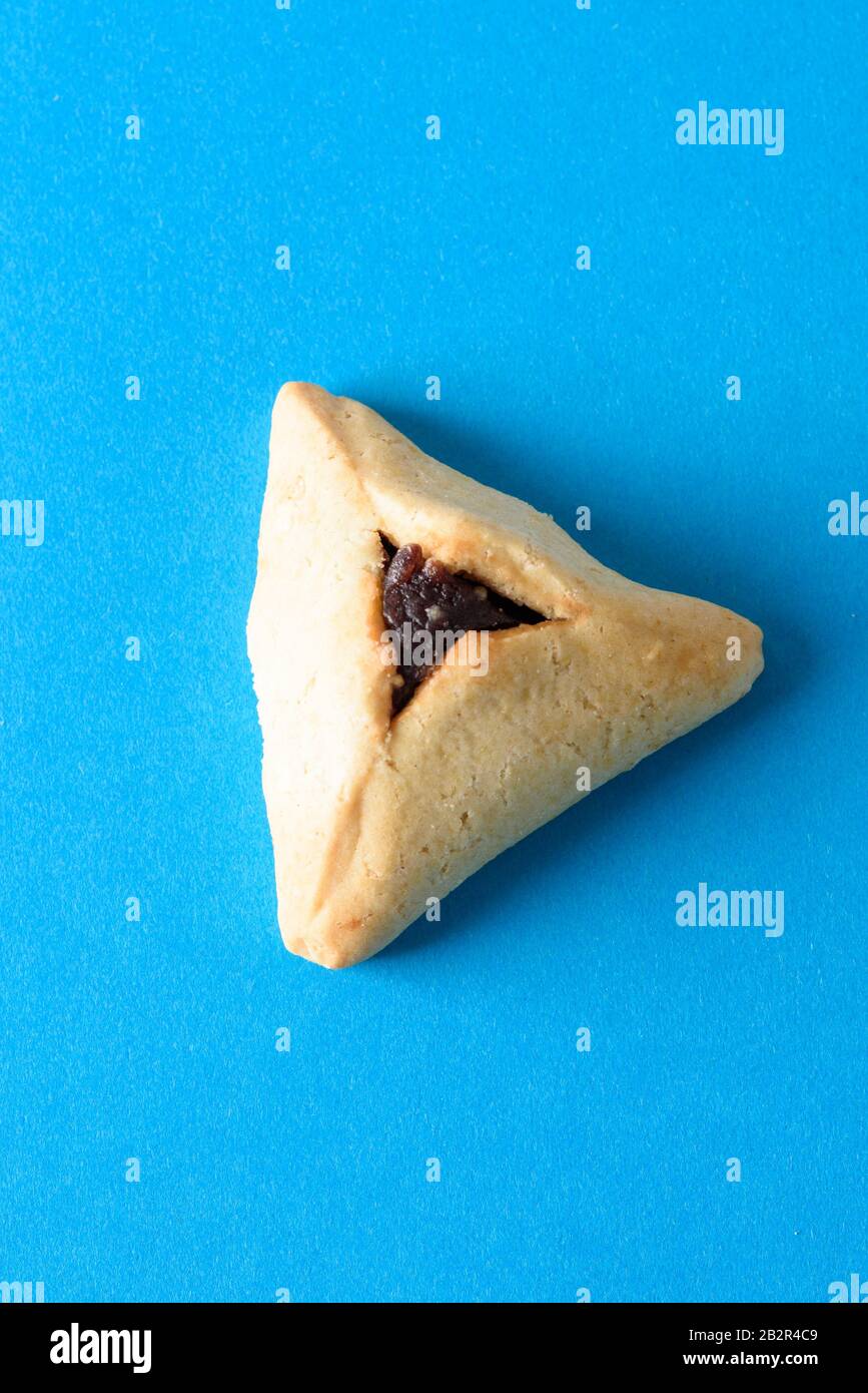 Purim holiday concept. One Hamantash on blue background. Hamantaschen