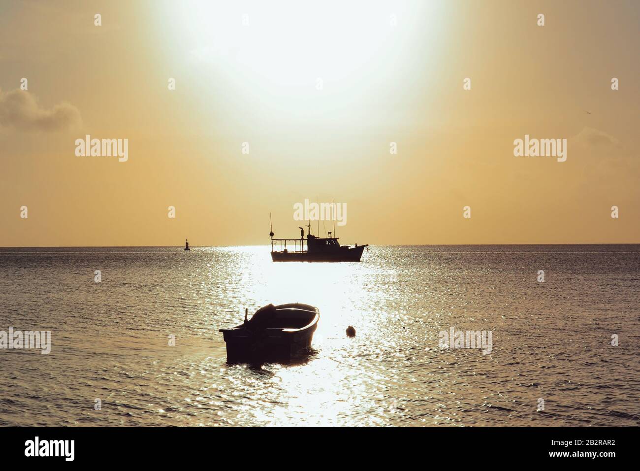 Scenery of sunset with silhouette boats in the sea Stock Photo - Alamy
