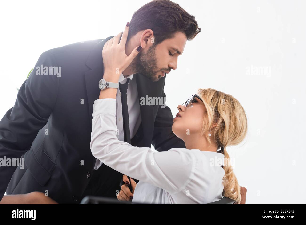 Sexy businesswoman pulling tie of businessman in office Stock Photo