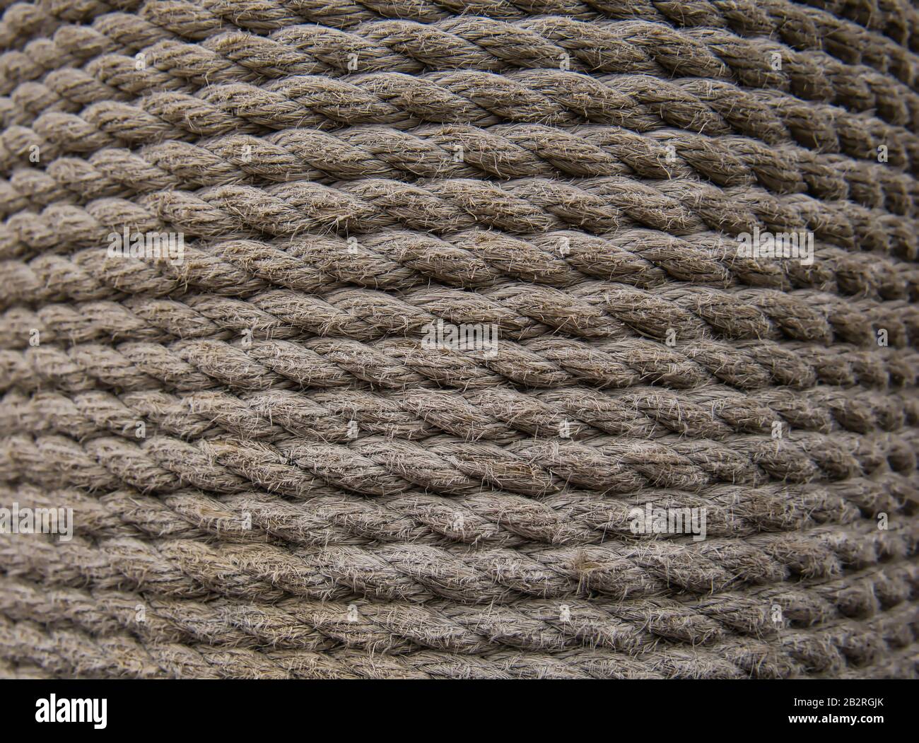 A wooden plank at the harbour wrapped in a thick ships rope Stock Photo
