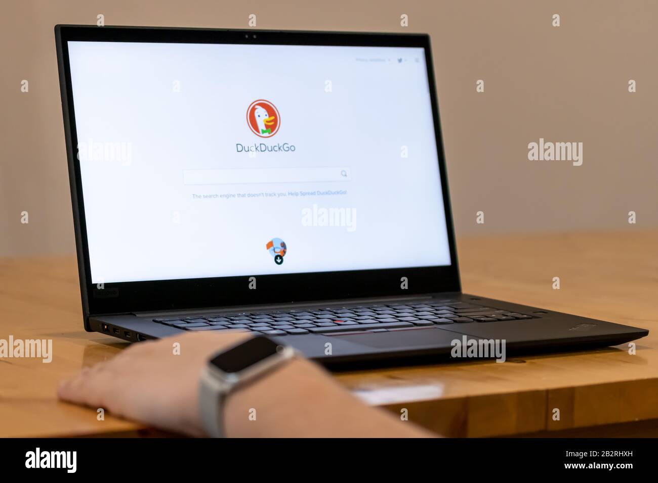 Person sitting at a desk, using DuckDuckGo internet search engine. Stock Photo