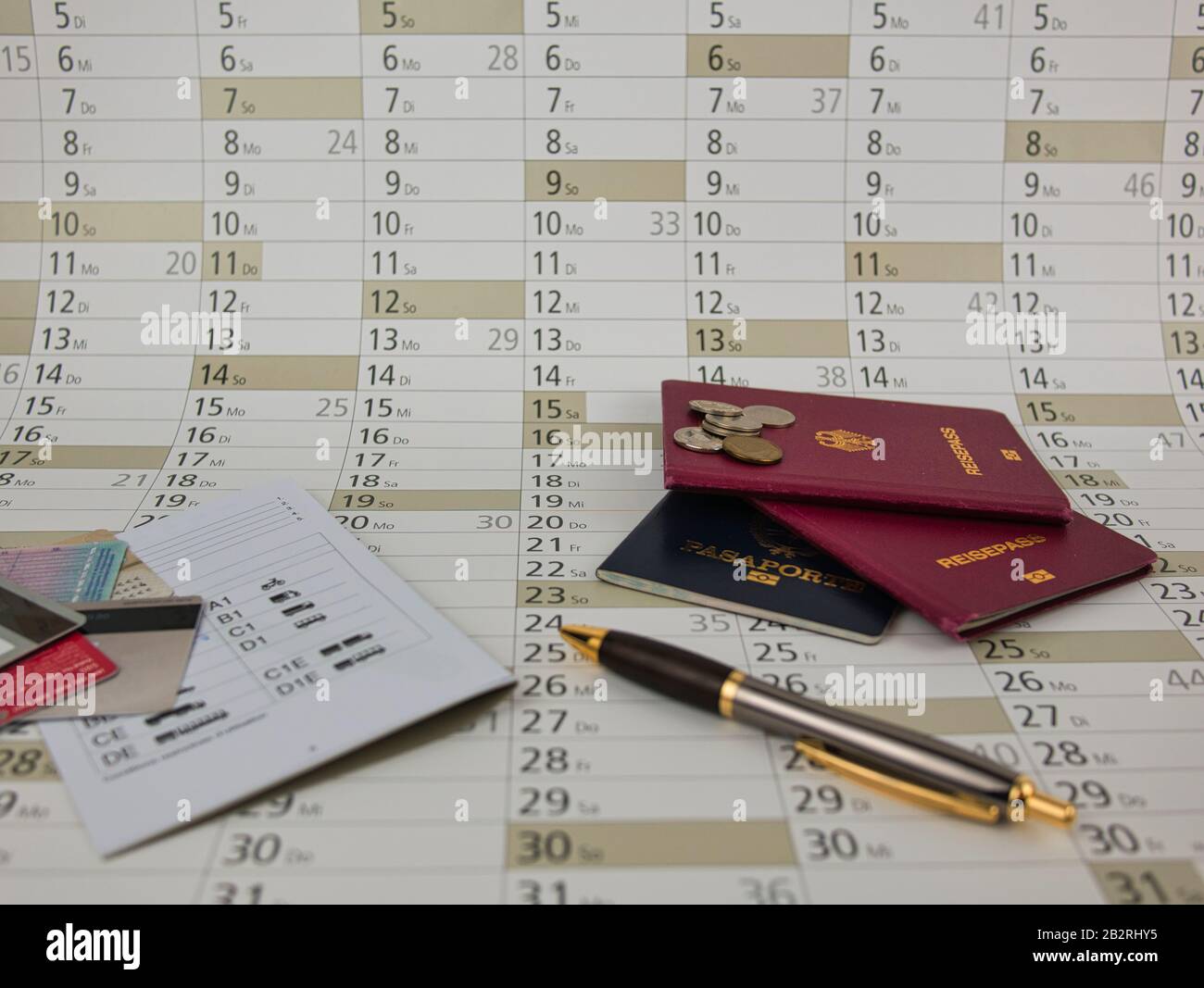 A calendar to plan with ballpoint pen Coins and passports Stock Photo