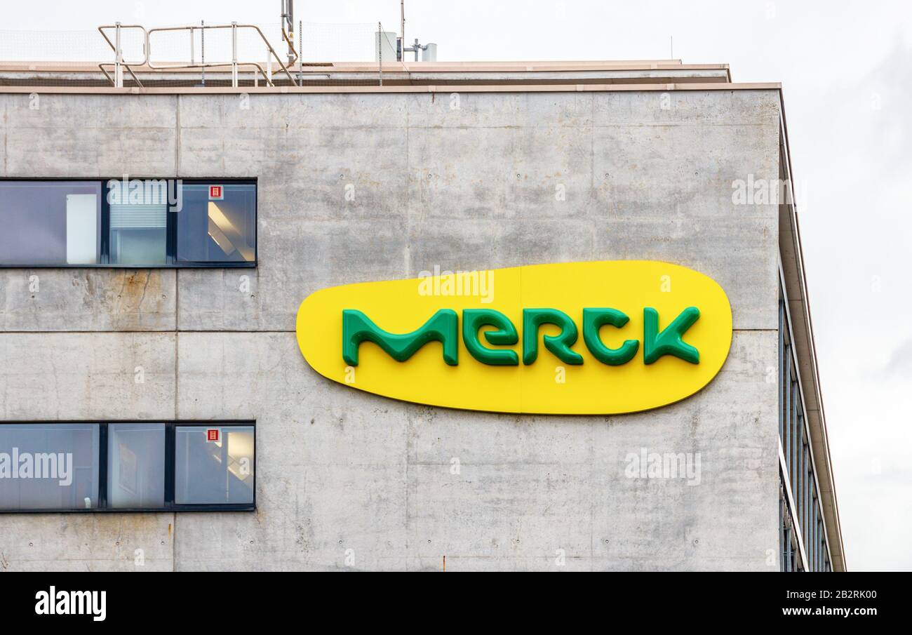 Large yellow green Merck logo at a concrete wall of a Merck building. Merck is a German multinational. Darmstadt, Germany. Stock Photo