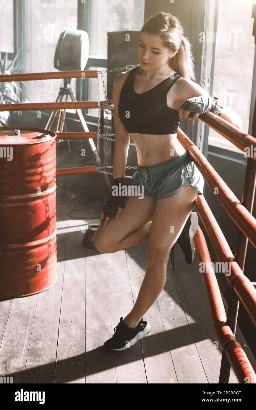 Young pretty boxer woman standing on ring. Full body portrait of