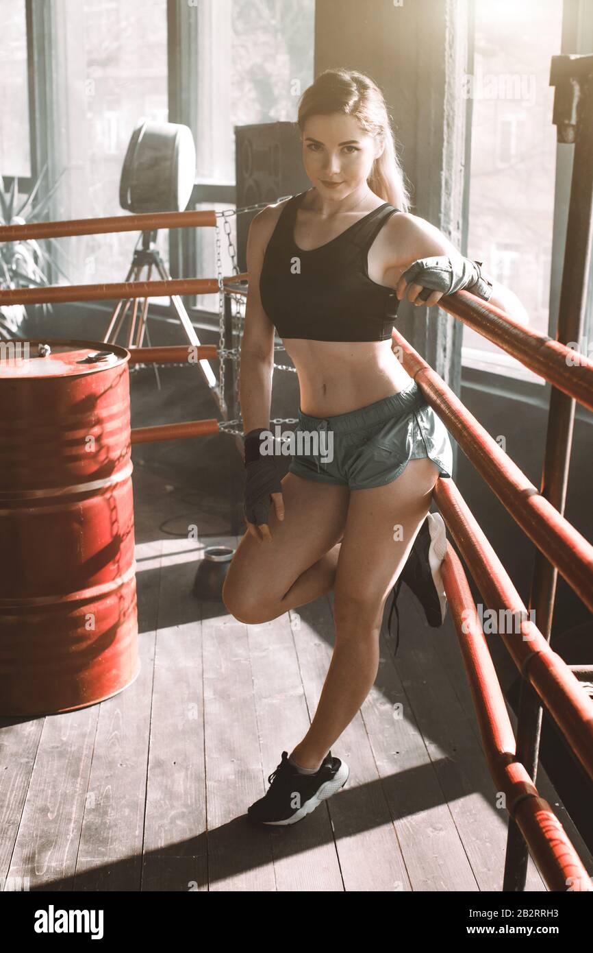https://c8.alamy.com/comp/2B2RRH3/young-pretty-boxer-woman-standing-on-ring-full-body-portrait-of-boxer-woman-wearing-black-sports-bra-grey-trousers-trainers-standing-in-ring-and-2B2RRH3.jpg