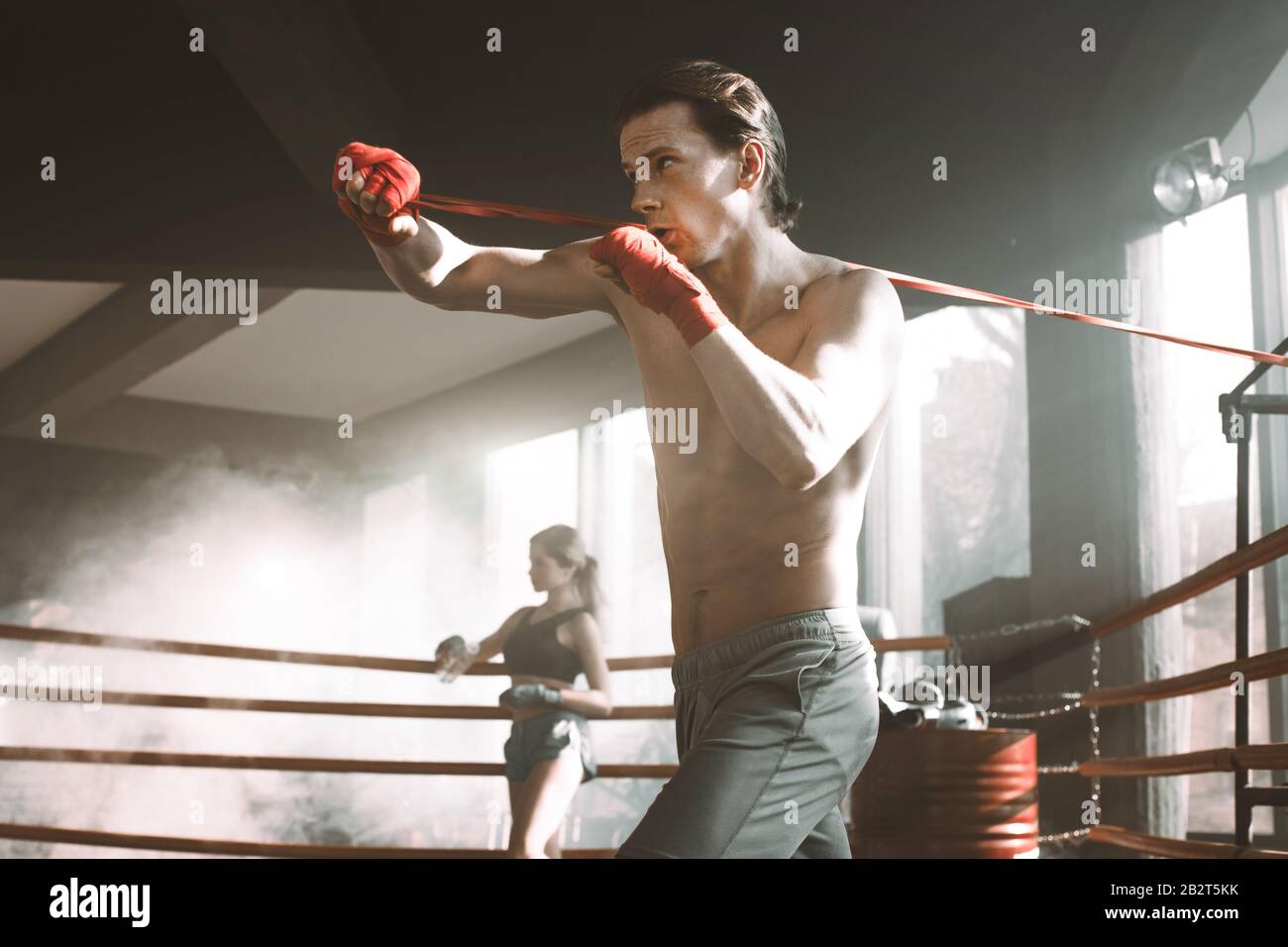 Handsome man working out with resistance band in the boxing ring at the  gym.. Perfectly shaped arm and back muscles Stock Photo - Alamy