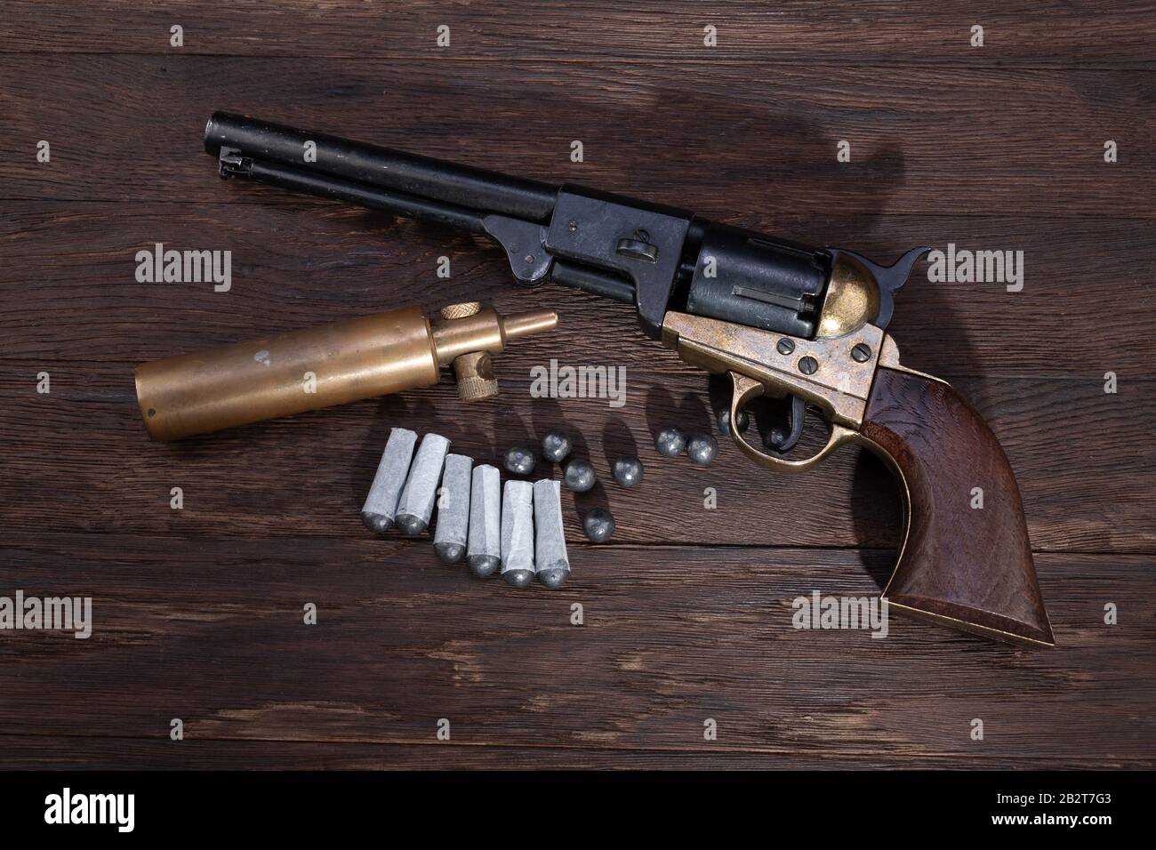 https://c8.alamy.com/comp/2B2T7G3/firearms-of-the-old-west-percussion-army-revolver-with-paper-cartridges-bullets-and-powder-flask-and-wooden-table-2B2T7G3.jpg