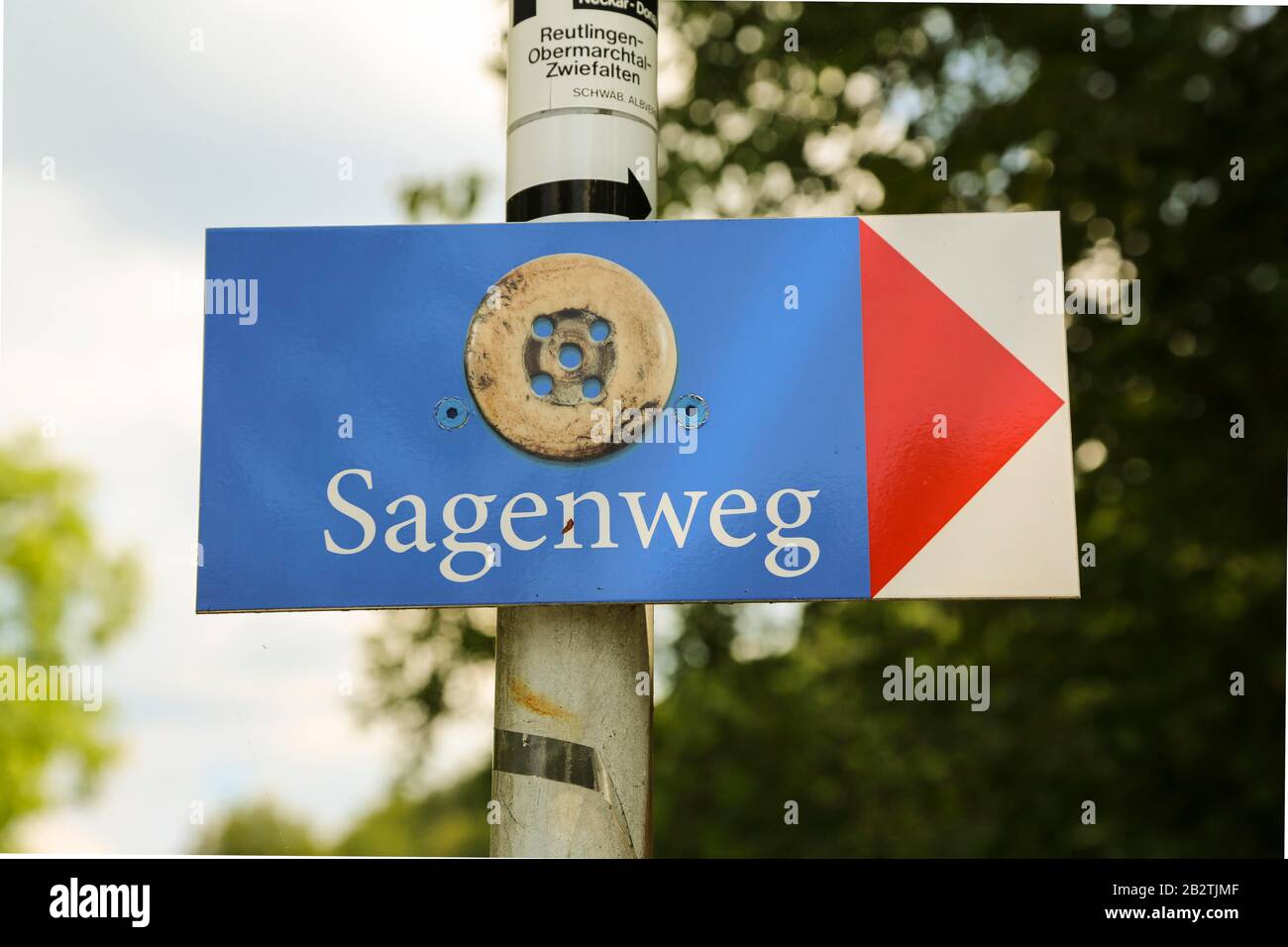 Pfullinger Sagenweg, signpost with symbol Remmseles, trouser button, shield, world of legends, wooden art, wooden figures carved with a chainsaw Stock Photo
