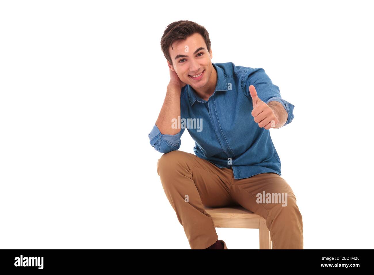relaxed seated casual man making the ok thumbs up hand sign on white ...