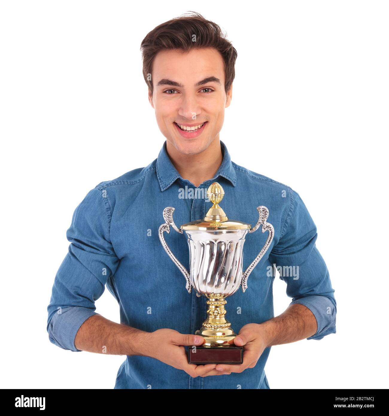 happy casual man holding big trophy cup on white background Stock Photo ...