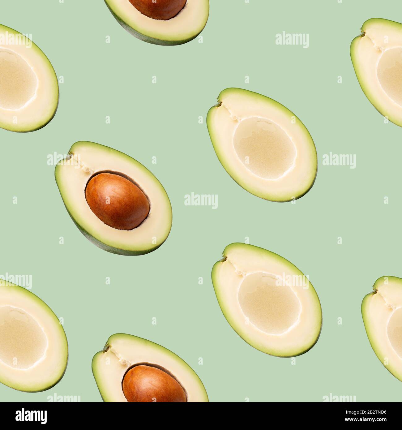 pattern with avocado slices on a green background. Stock Photo