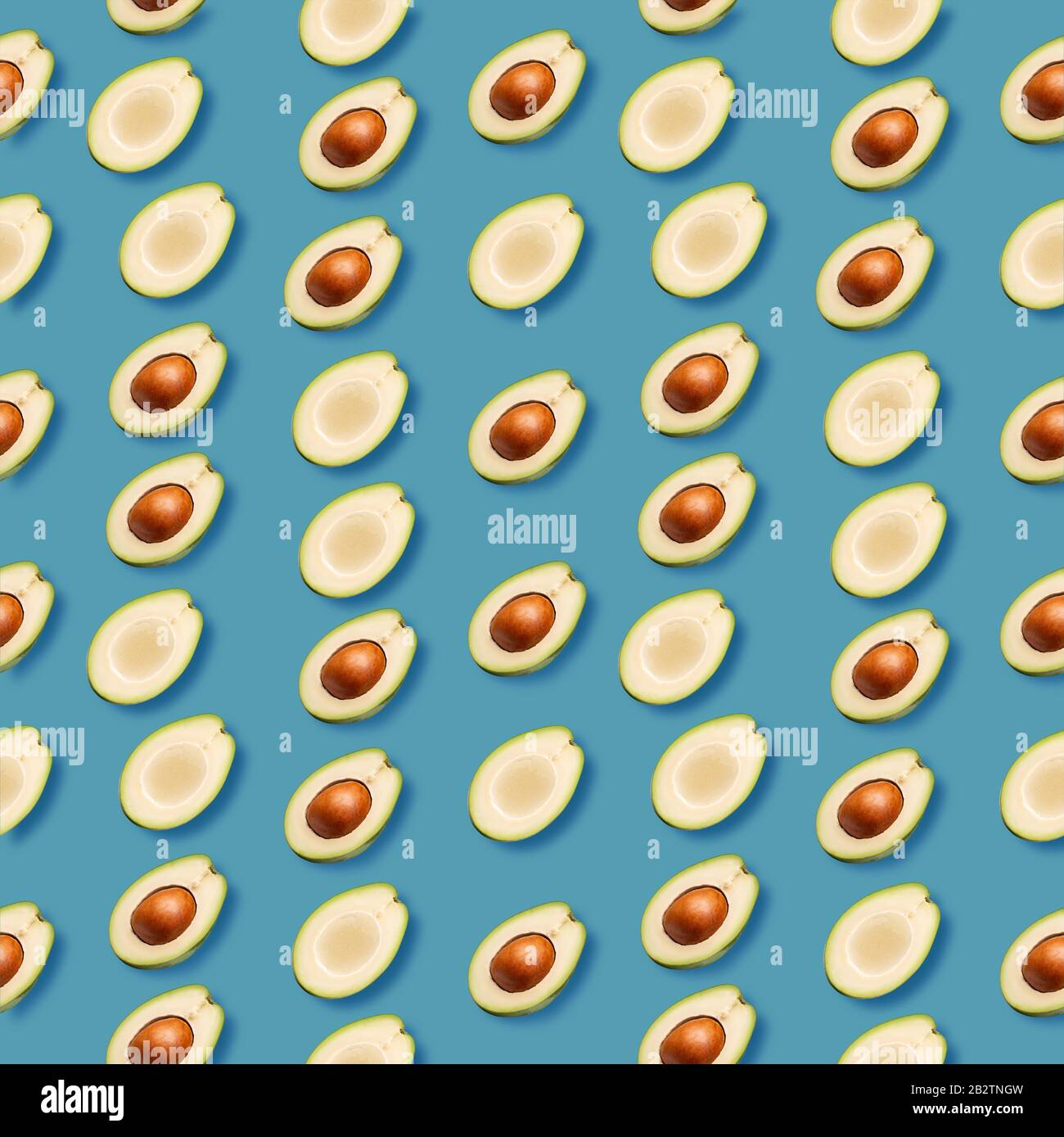 pattern with avocado slices on a blue background. Stock Photo