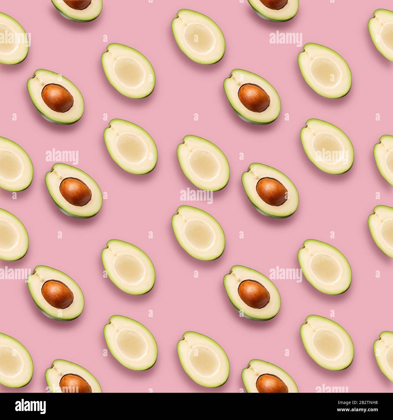 pattern with avocado slices on a pink background. Stock Photo