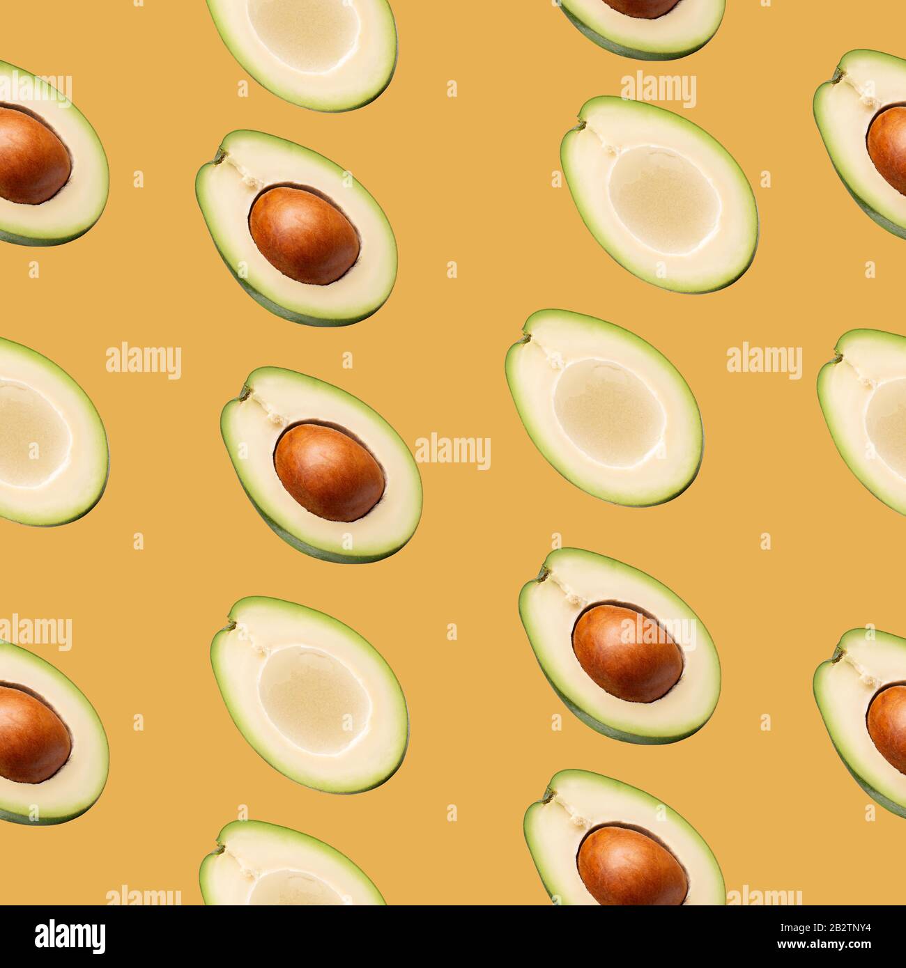 pattern with avocado slices on a yellow background. Stock Photo