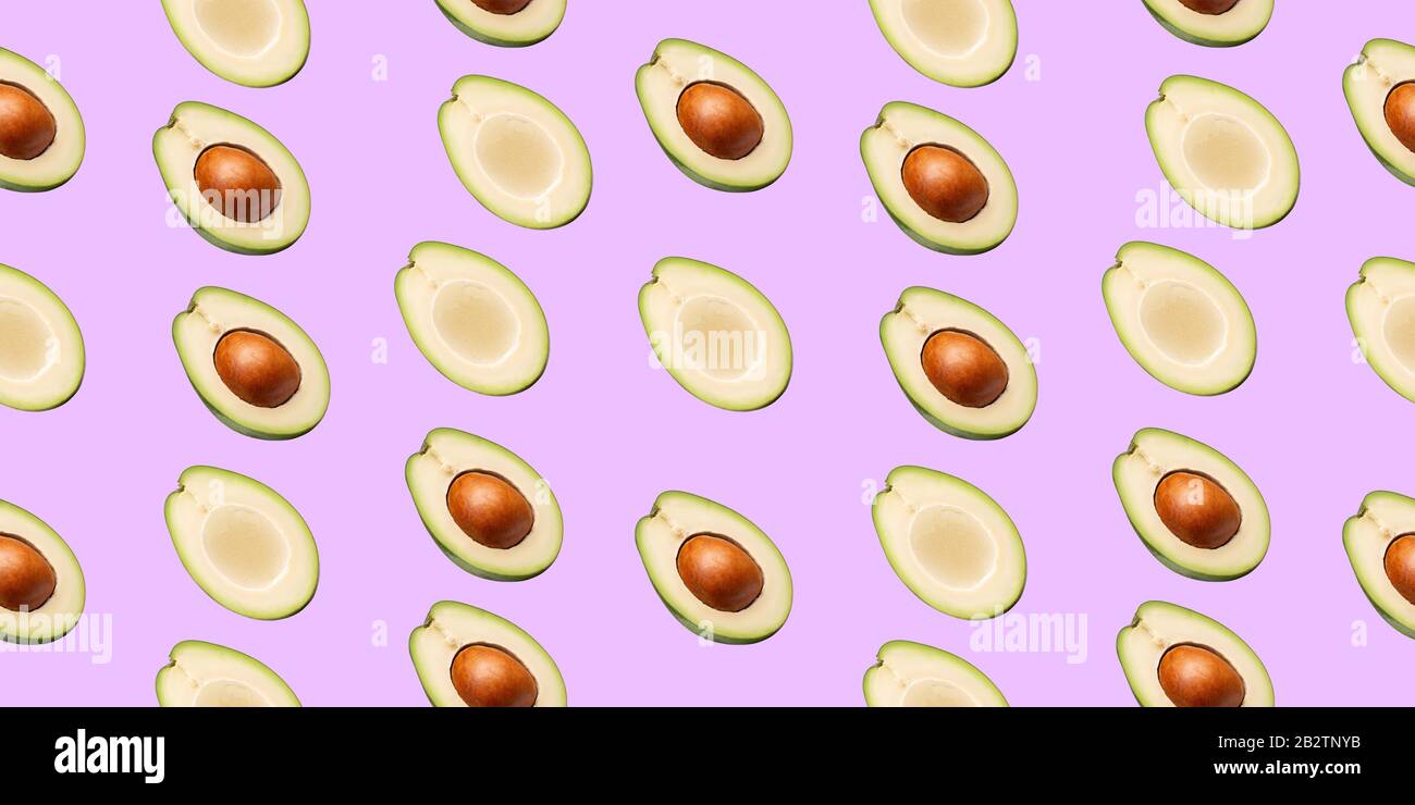 pattern with avocado slices on a pink background. Stock Photo