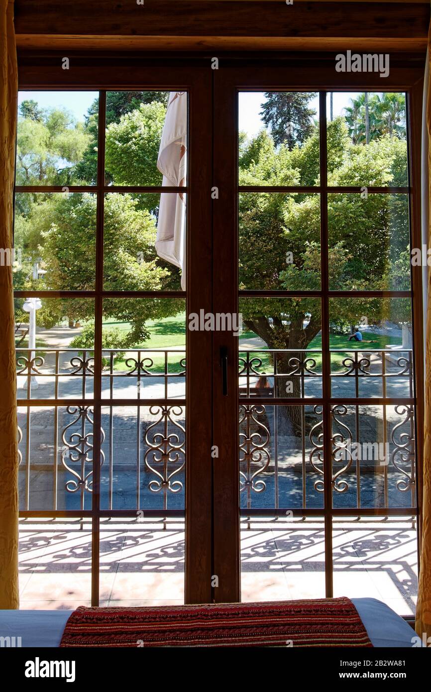 view from window, park, greenery, wrought iron railing, balcony, Hotel Santa Cruz Plaza, Santa Cruz, Chile, South America; summer Stock Photo